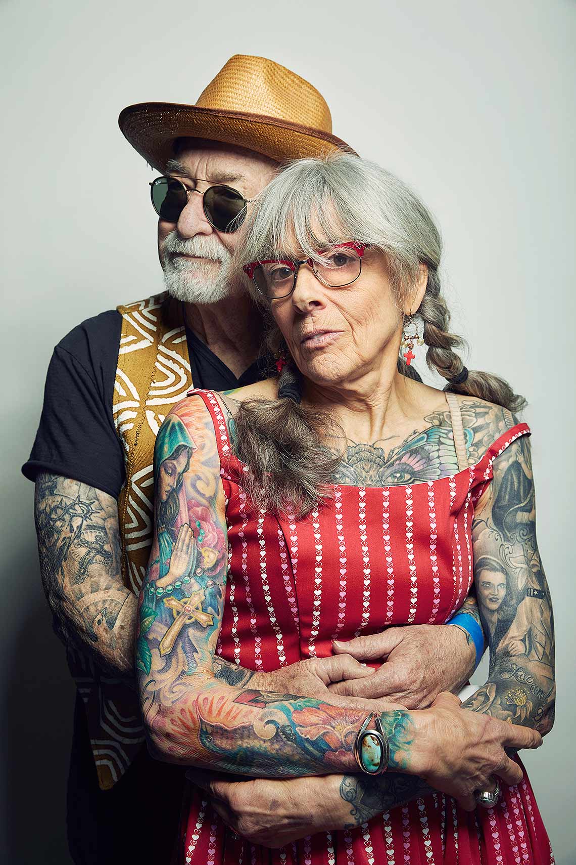 senior citizen couples with tattoos holding each other. 